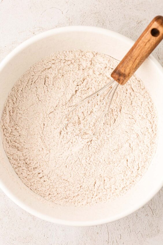 Dry ingredients for cookies being whisked in a bowl.