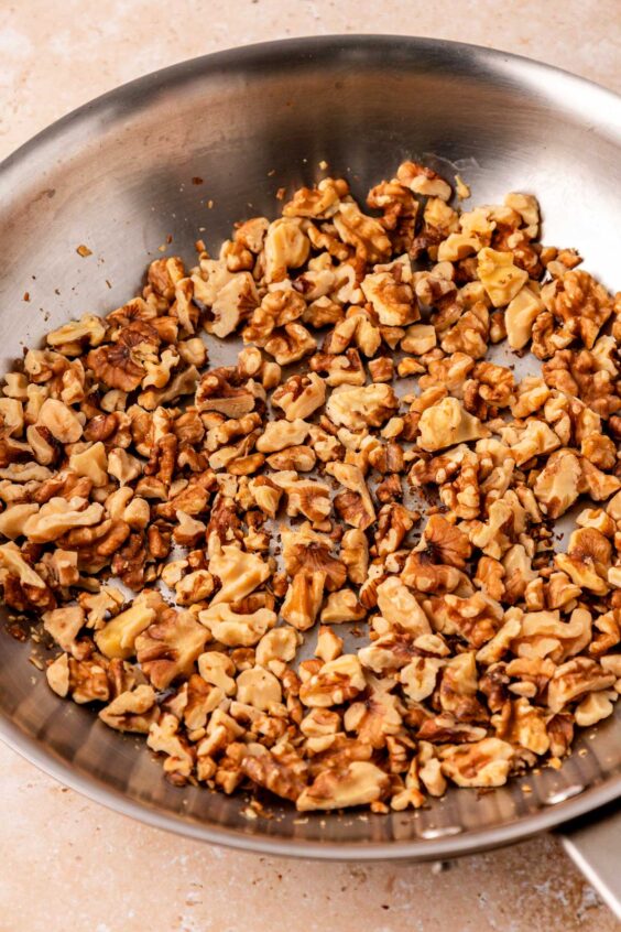 Walnuts being toasted in a skillet.