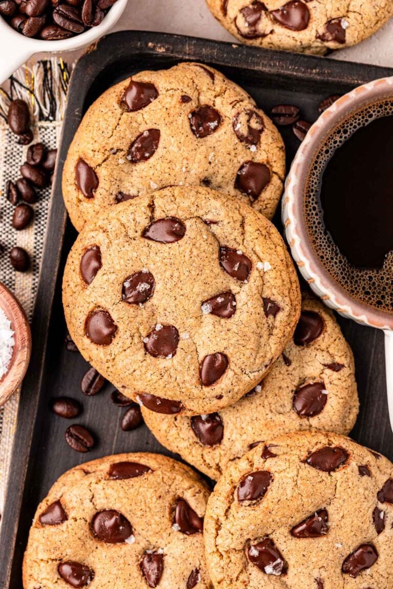 Overhead photo of Espresso Chocolate Chip Cookies on a cookie sheet with a mug of coffee.