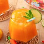 Close up of a glass or orange Easter punch on a rattan coaster.