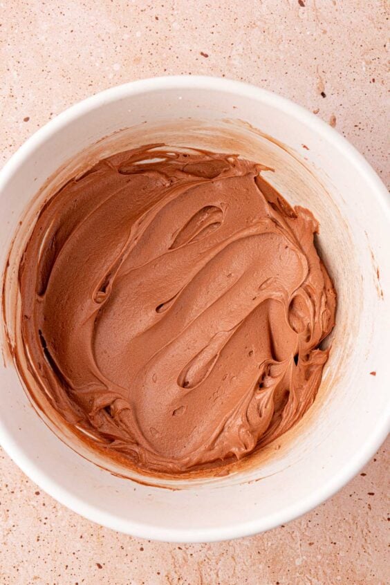 Chocolate frosting in a white bowl.