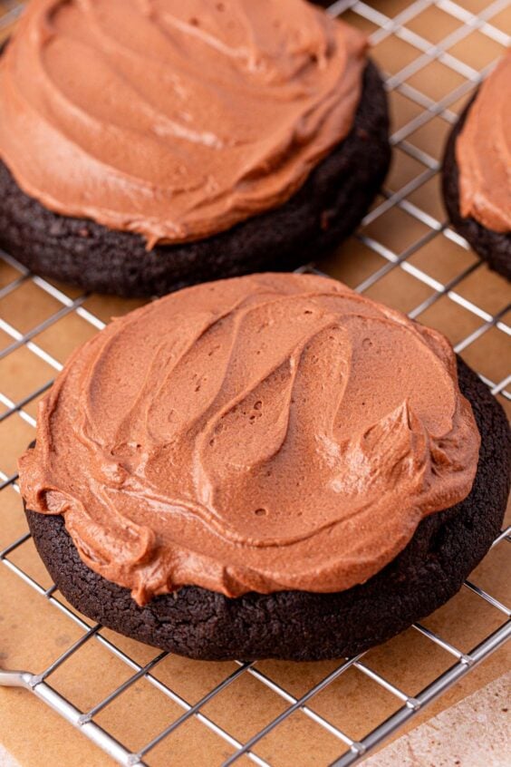 Frosted chocolate cookies on a wire rack.