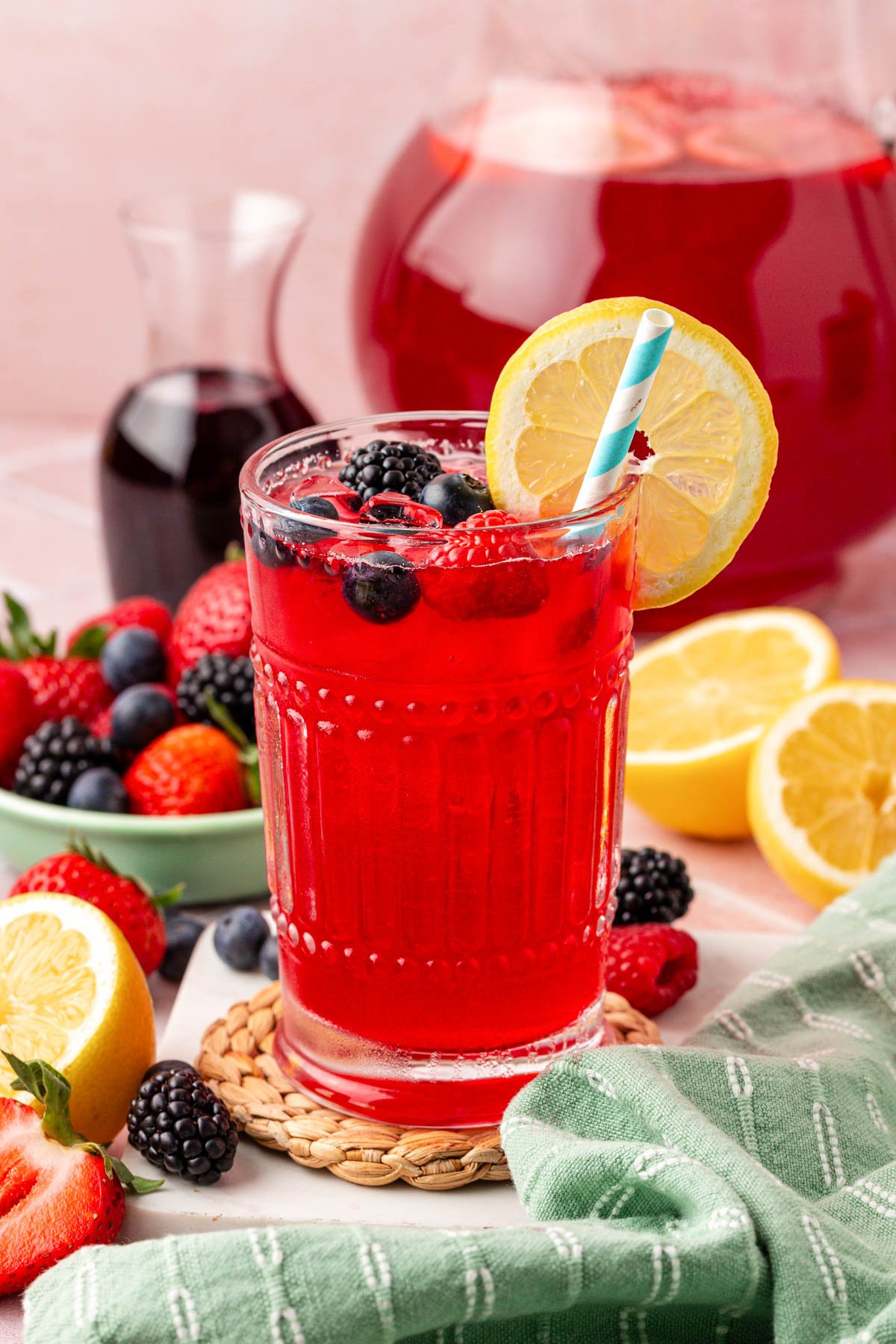 A glass with berry lemonade in it.