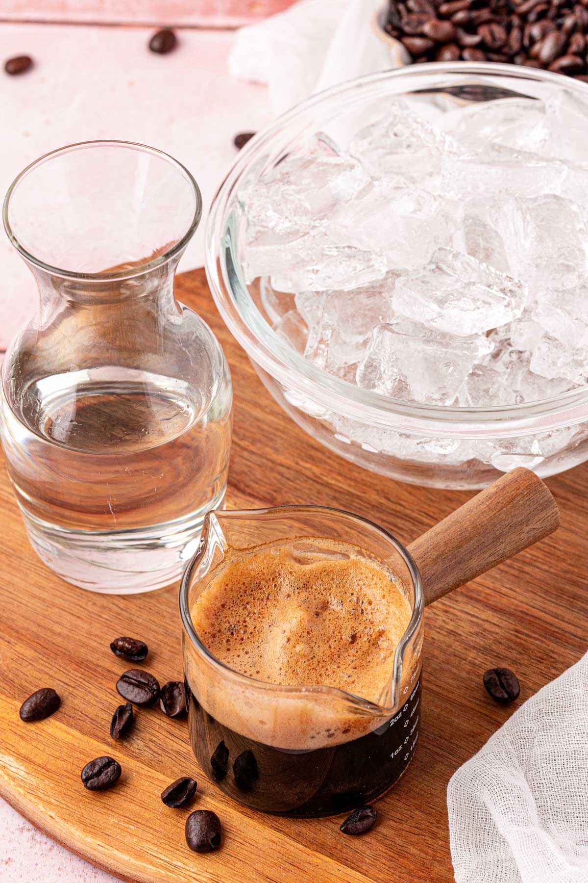 Ingredients to make a non alcoholic espresso martini on a wooden table.
