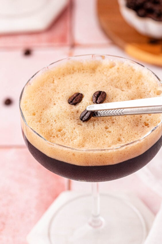 coffee beans being added as garnish to a virgin espresso martini.