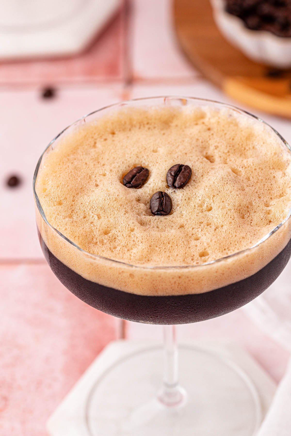 Close up of a coupe glass with a caffe shakerato in it.