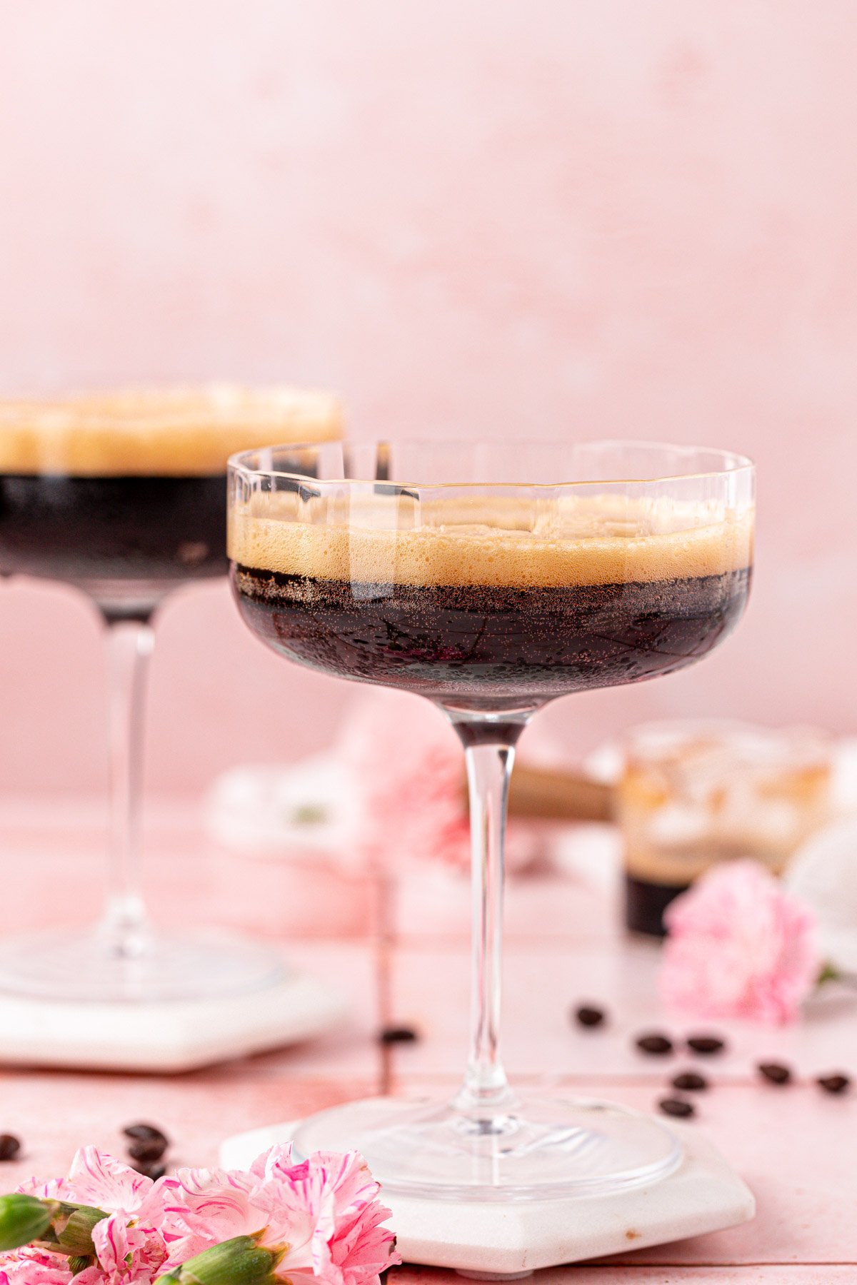 Two coupe glasses with non alcoholic espresso martinis in them.