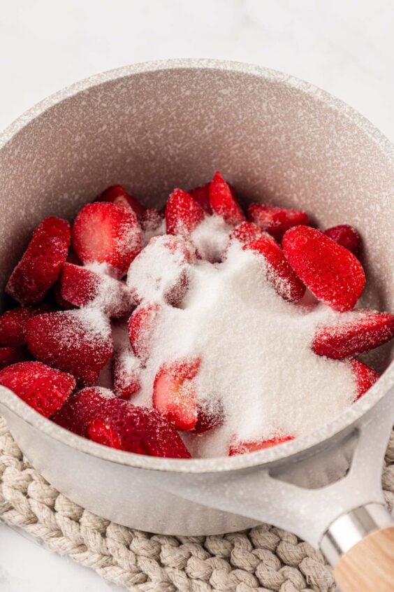 Strawberries and sugar in a pot.
