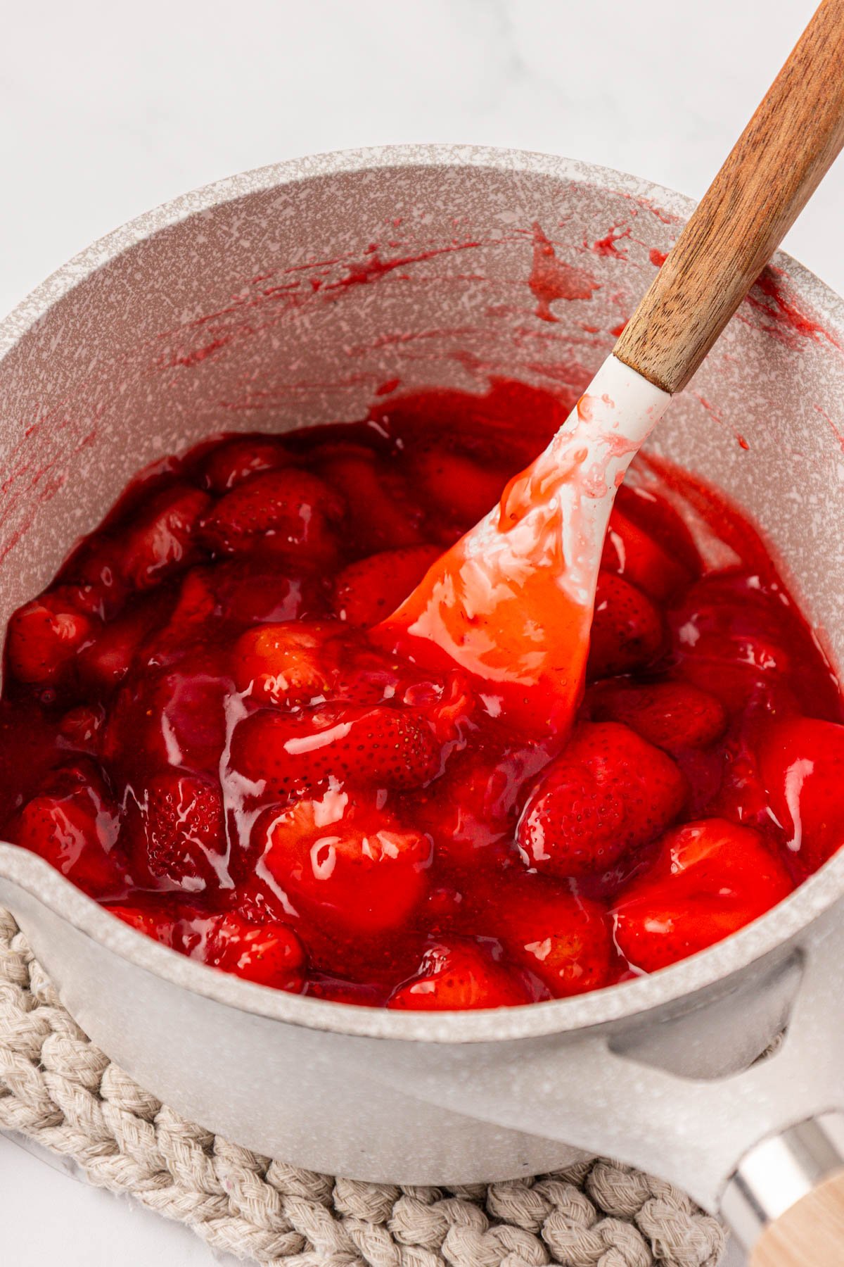 Close up of a pot filled with strawberry cake filling.