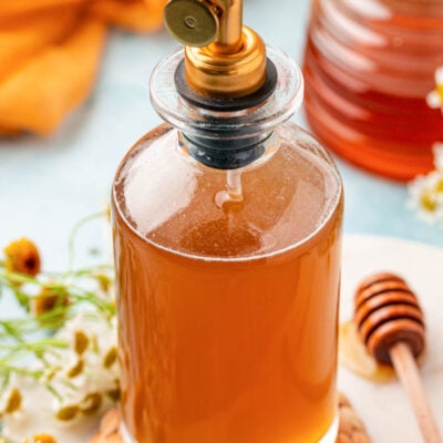 A bottle of honey simple syrup on a table.