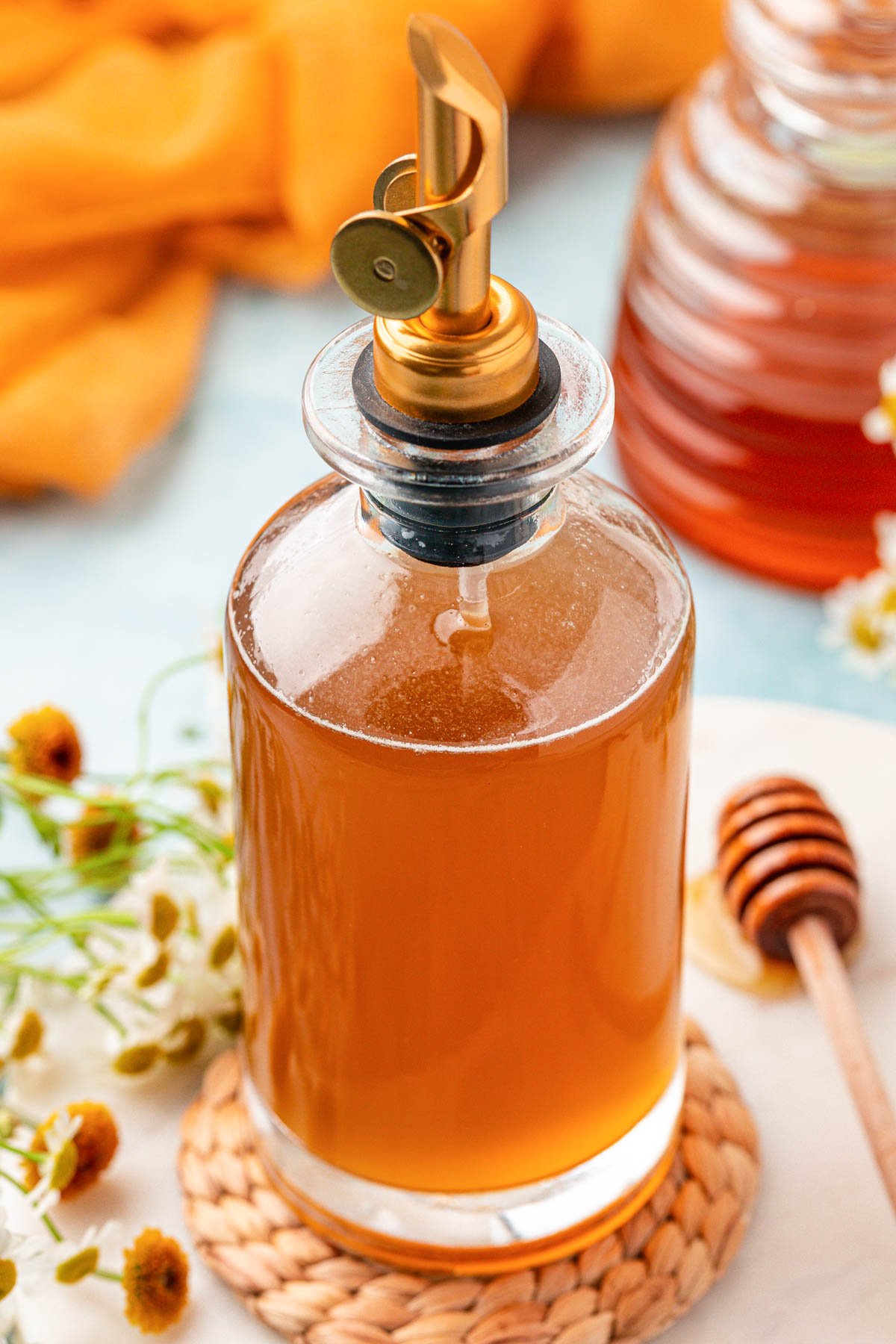 A bottle of honey simple syrup on a table.