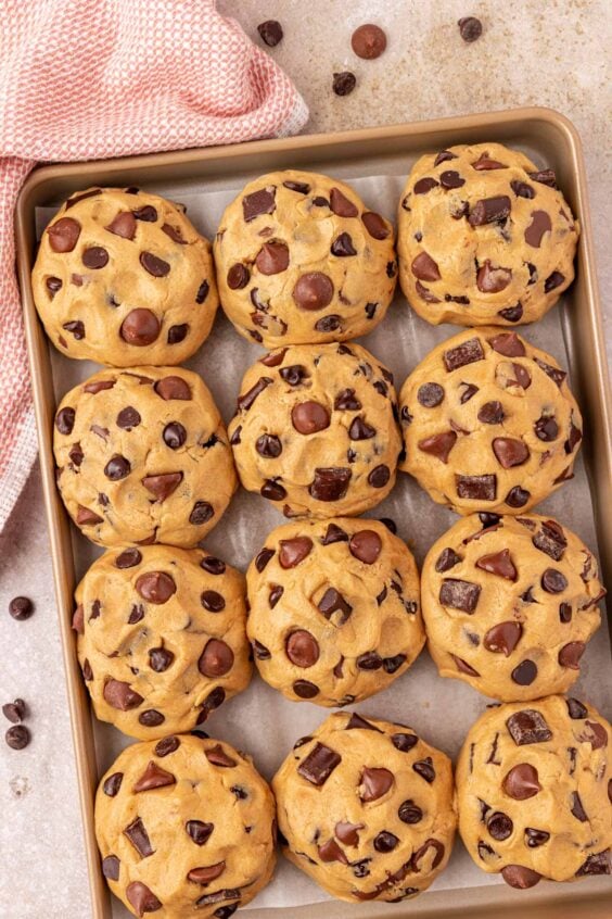 Overhead photo of balls of chocolate chunk cookie dough on a baking pan ready to chill.