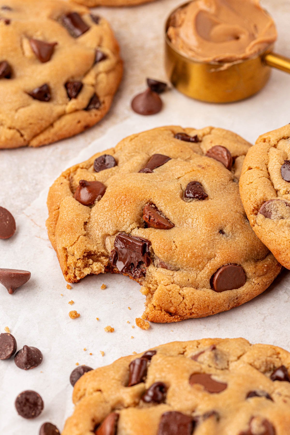 Chocolate Chunk Cookie with a bite missing from it on a counter with more around.