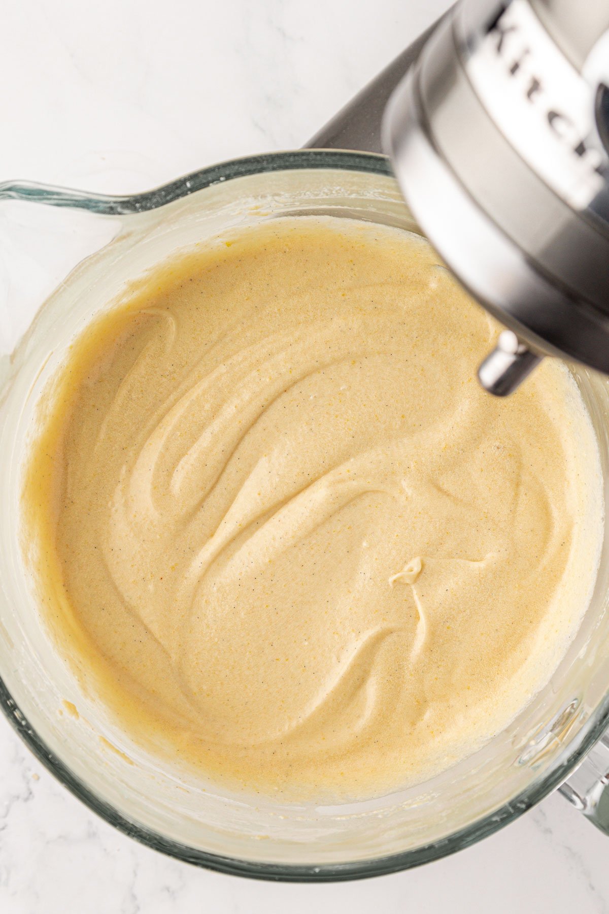 Stand mixer bowl with vanilla cake batter in it.