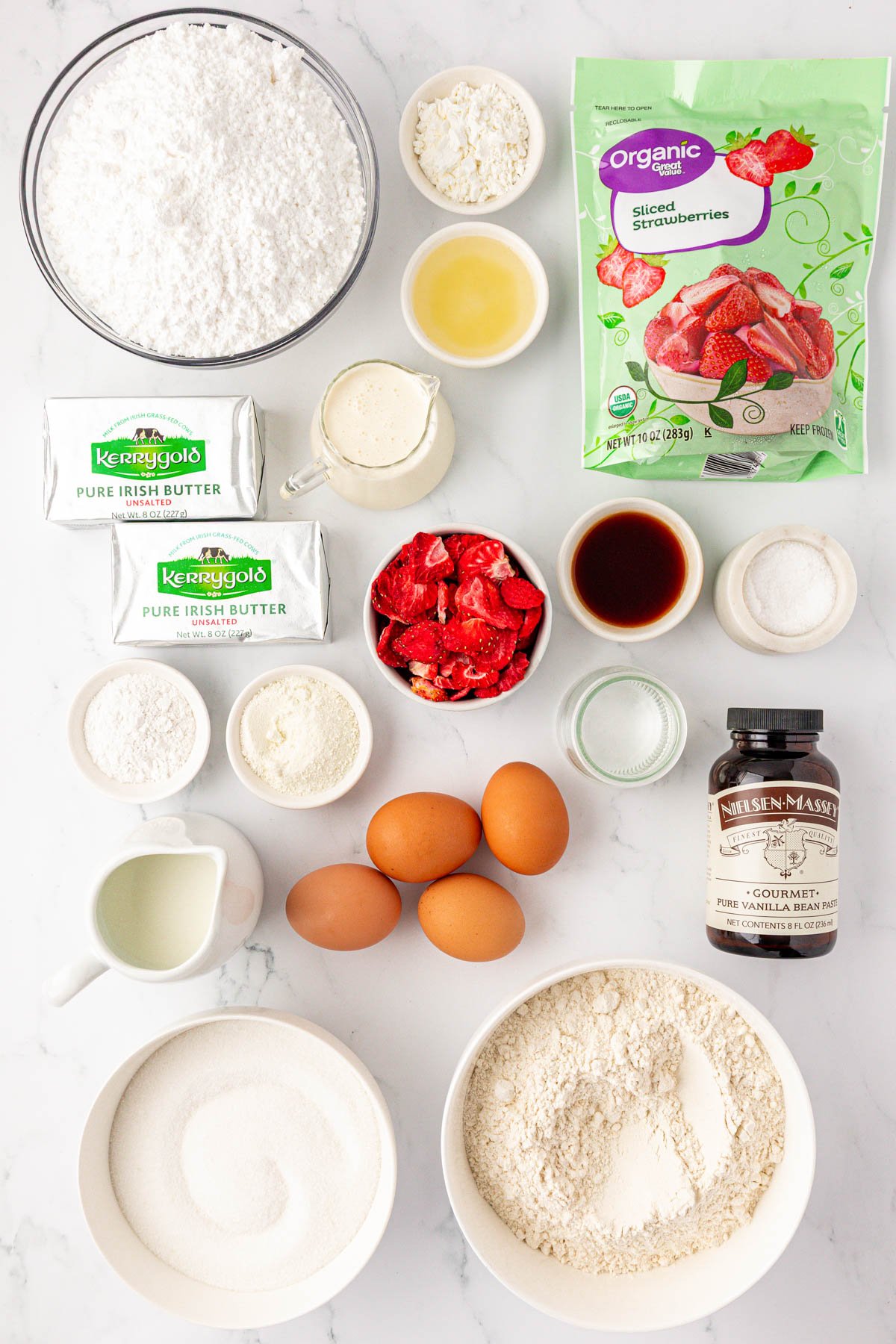 Overhead photo of ingredients to make strawberry vanilla cake on a table.