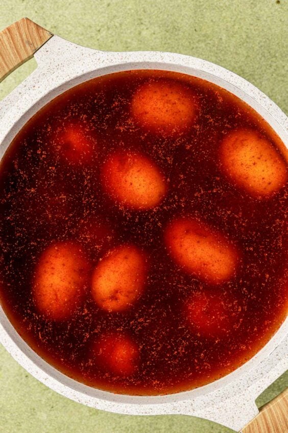 Potatoes in a pot with seasonings and water.