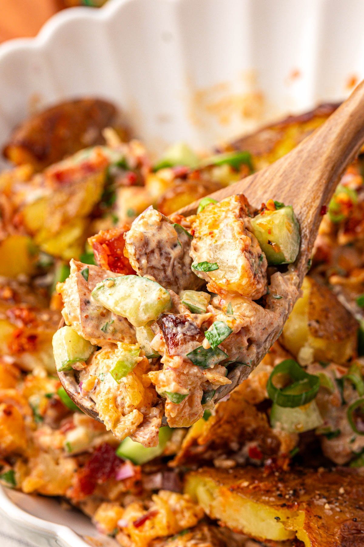 A serving spoon with a scoop of chili crisp potato salad.