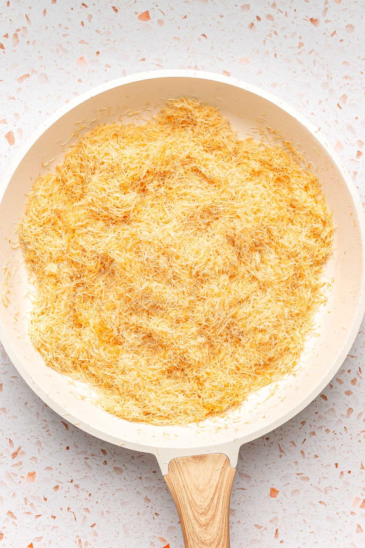 Toasted kataifi in a skillet.