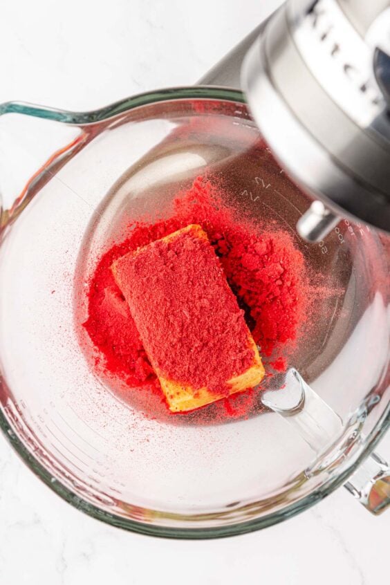Butter, strawberry powder, and salt being creamed in a mixing bowl.