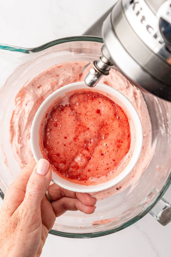 A small bowl of melted strawberry frosting.