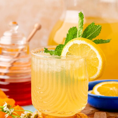 A cup of honey lemonade on a wooden coaster.