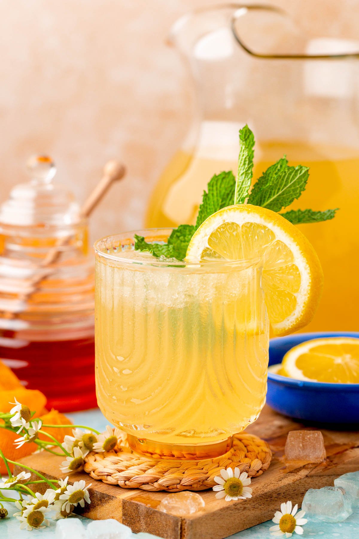 A cup of honey lemonade on a wooden coaster.
