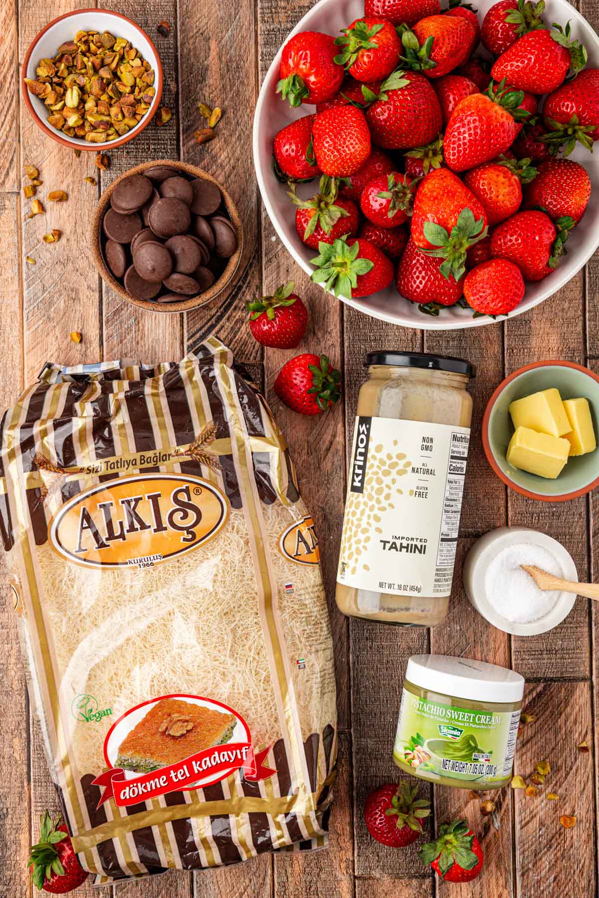 Ingredients to make Dubai Strawberry Cups on a wooden table.