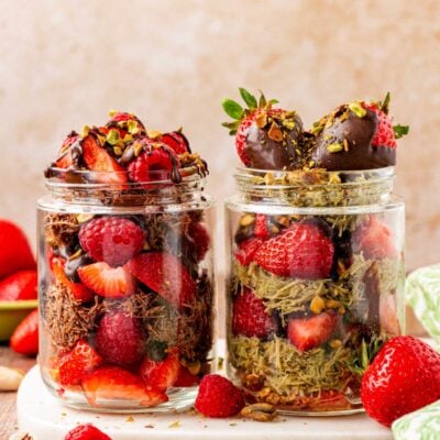 Dubai strawberry cups jars next to each other. One is made with pistachio cream and the other is made with Nutella.