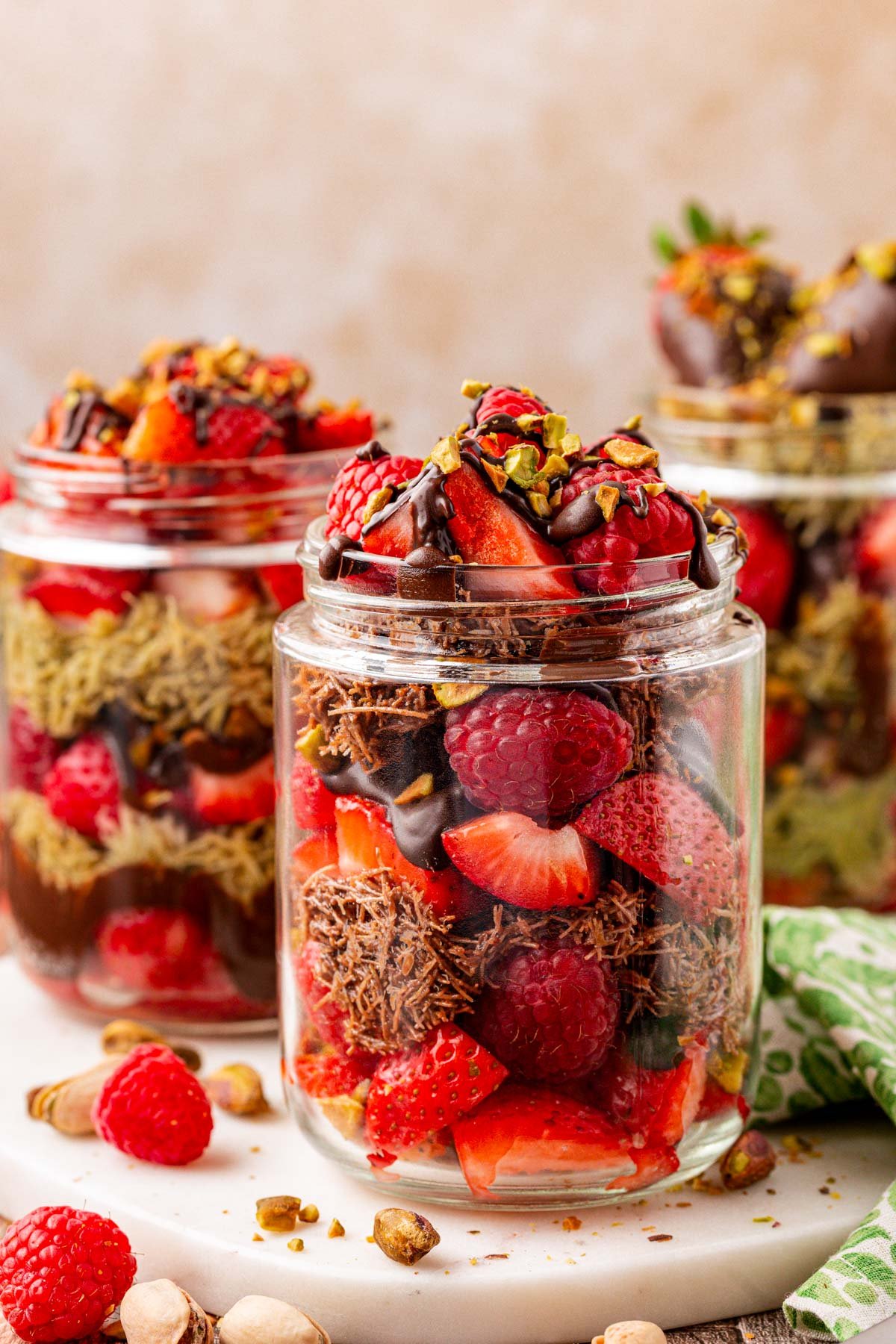 Jars of Dubai strawberry cups filled with both nutella and pistachio kataifi in a serving board.