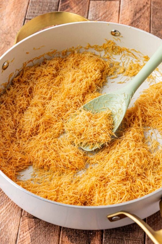 Kataifi dough being toasted in a skillet.
