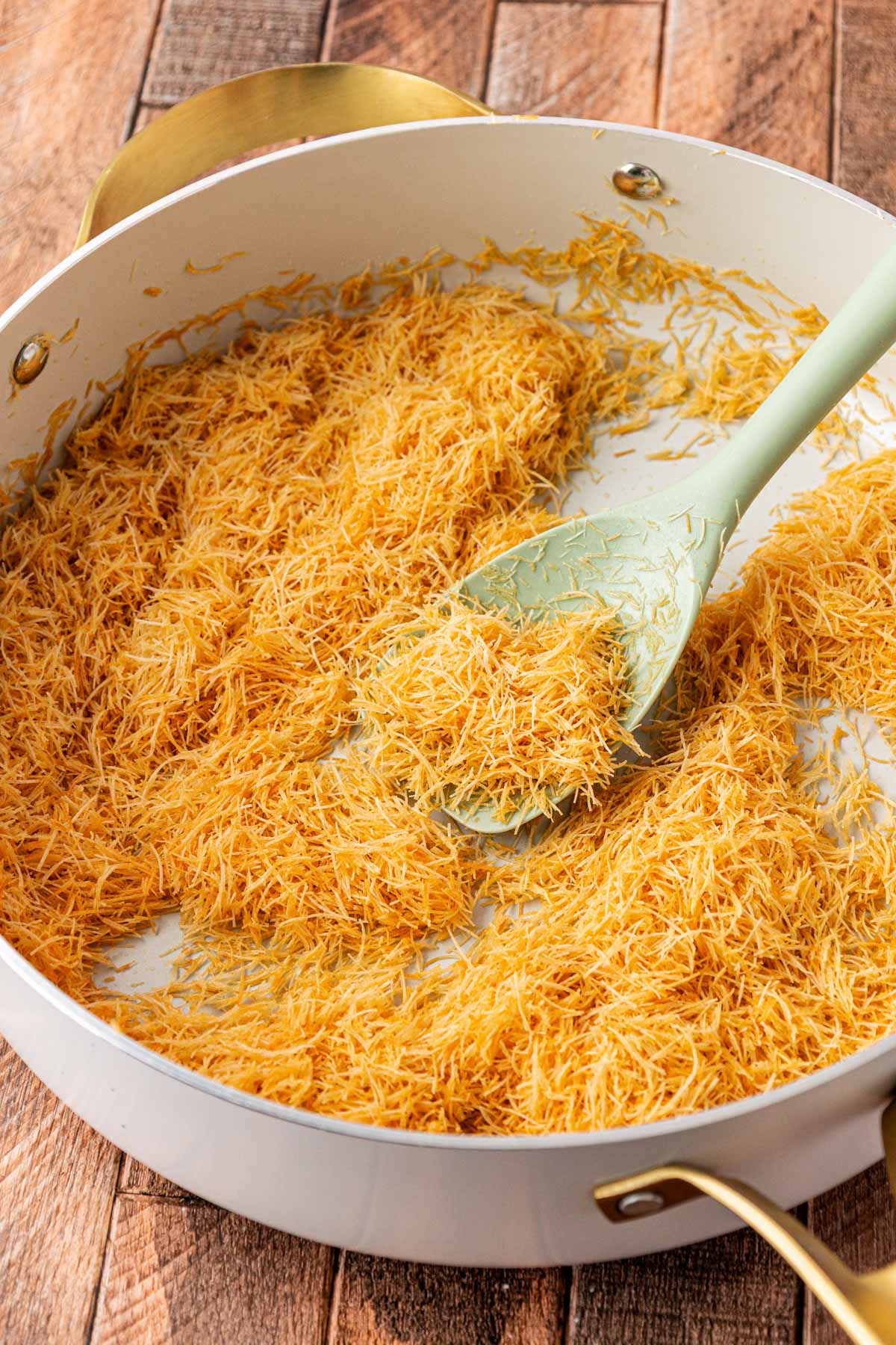 Kataifi dough being toasted in a skillet.