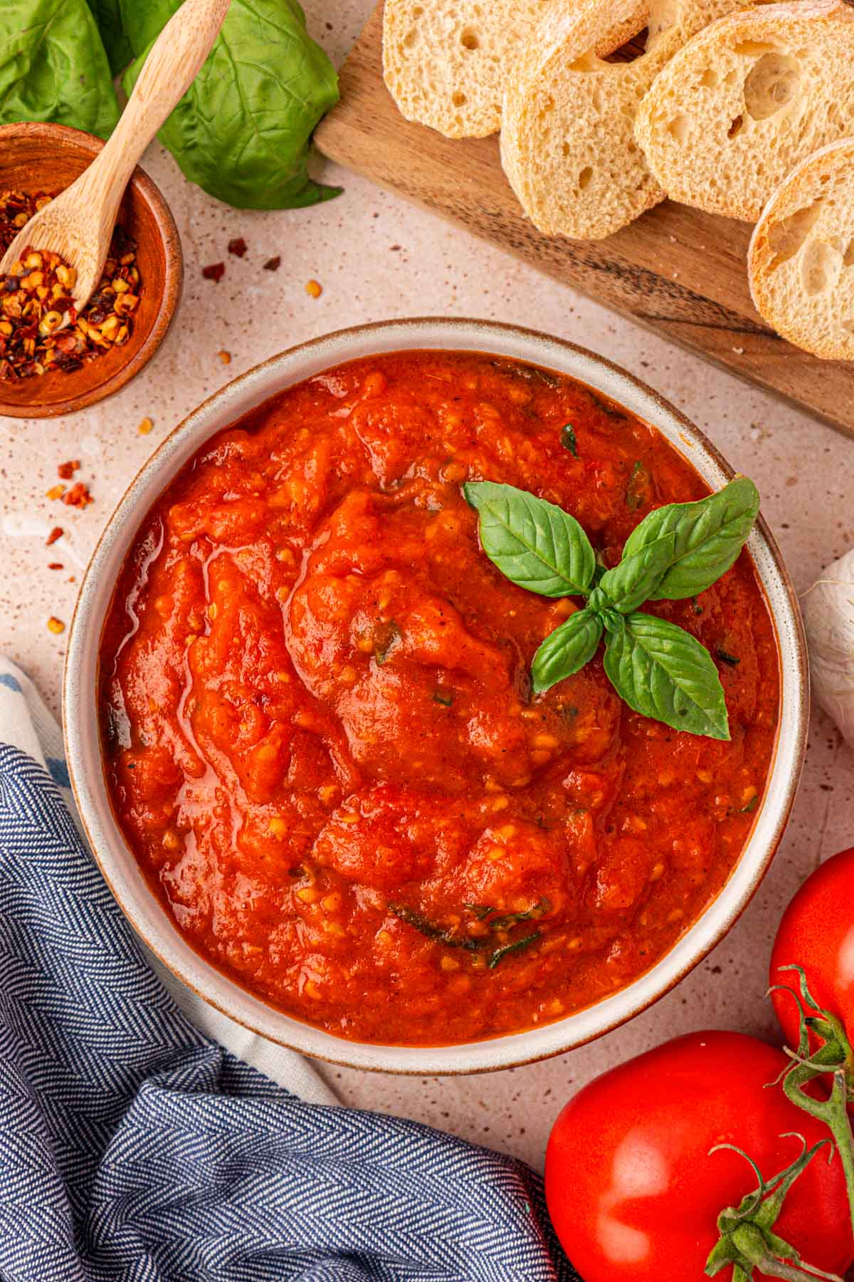 A bowl of fresh tomato sauce garnished with basil.