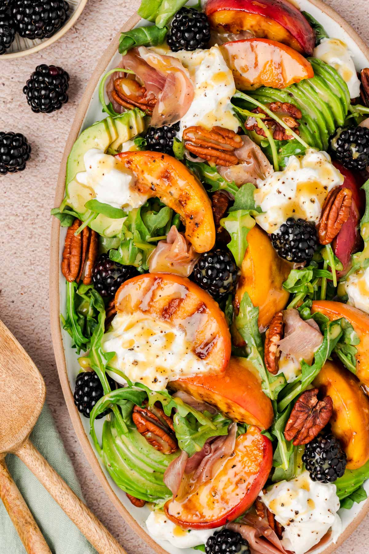 Close up of a burrata and peach salad on a plate.