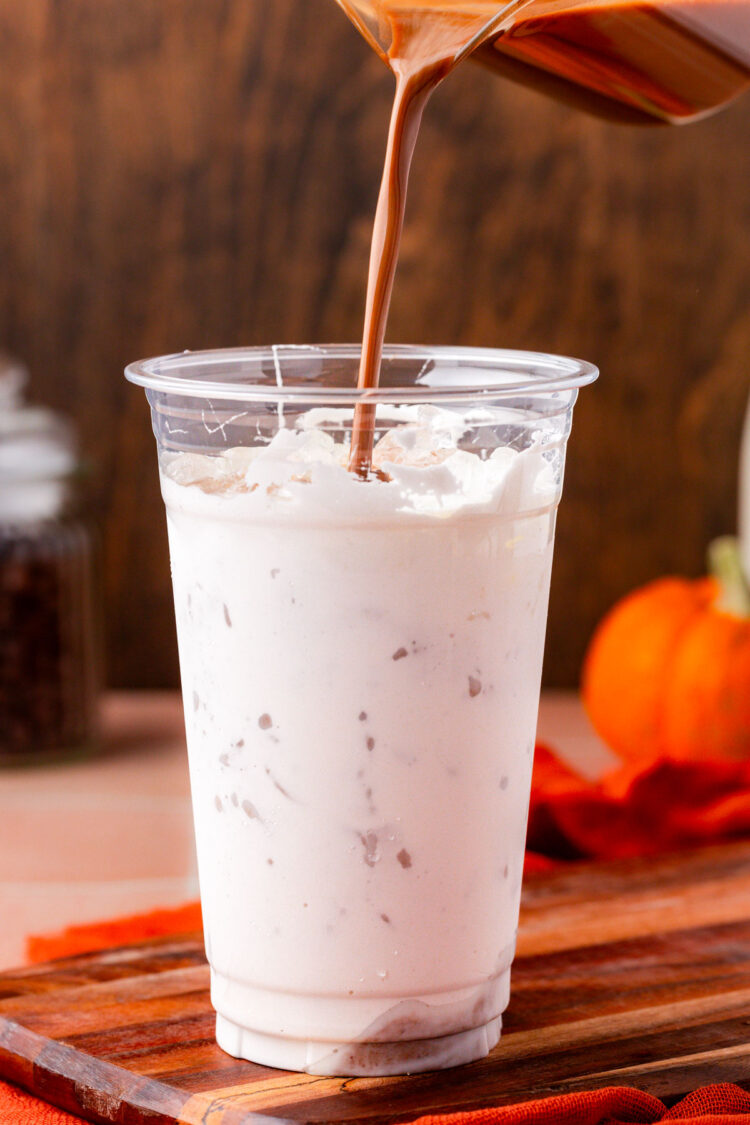 Espresso being poured into a cup with milk, ice, and marshmallow fluff.