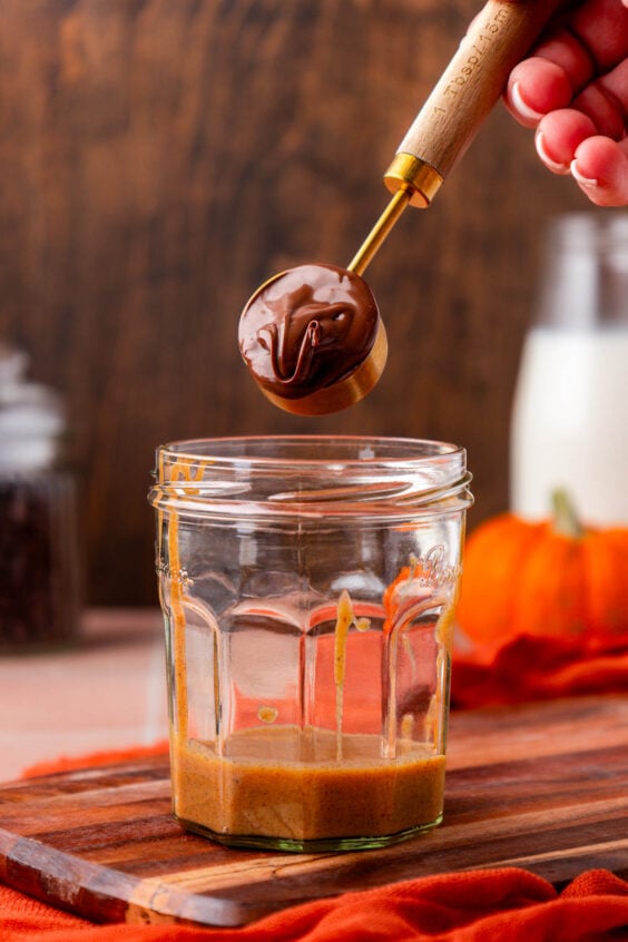 Nutella being spooned into a glass.
