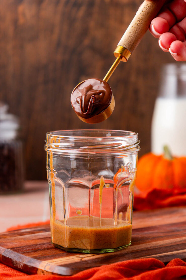 Nutella being spooned into a glass.