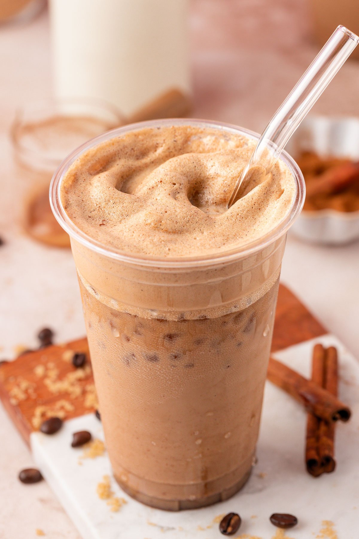 Viral French Toast Iced Latte with a foamy top in a plastic cup with a straw.
