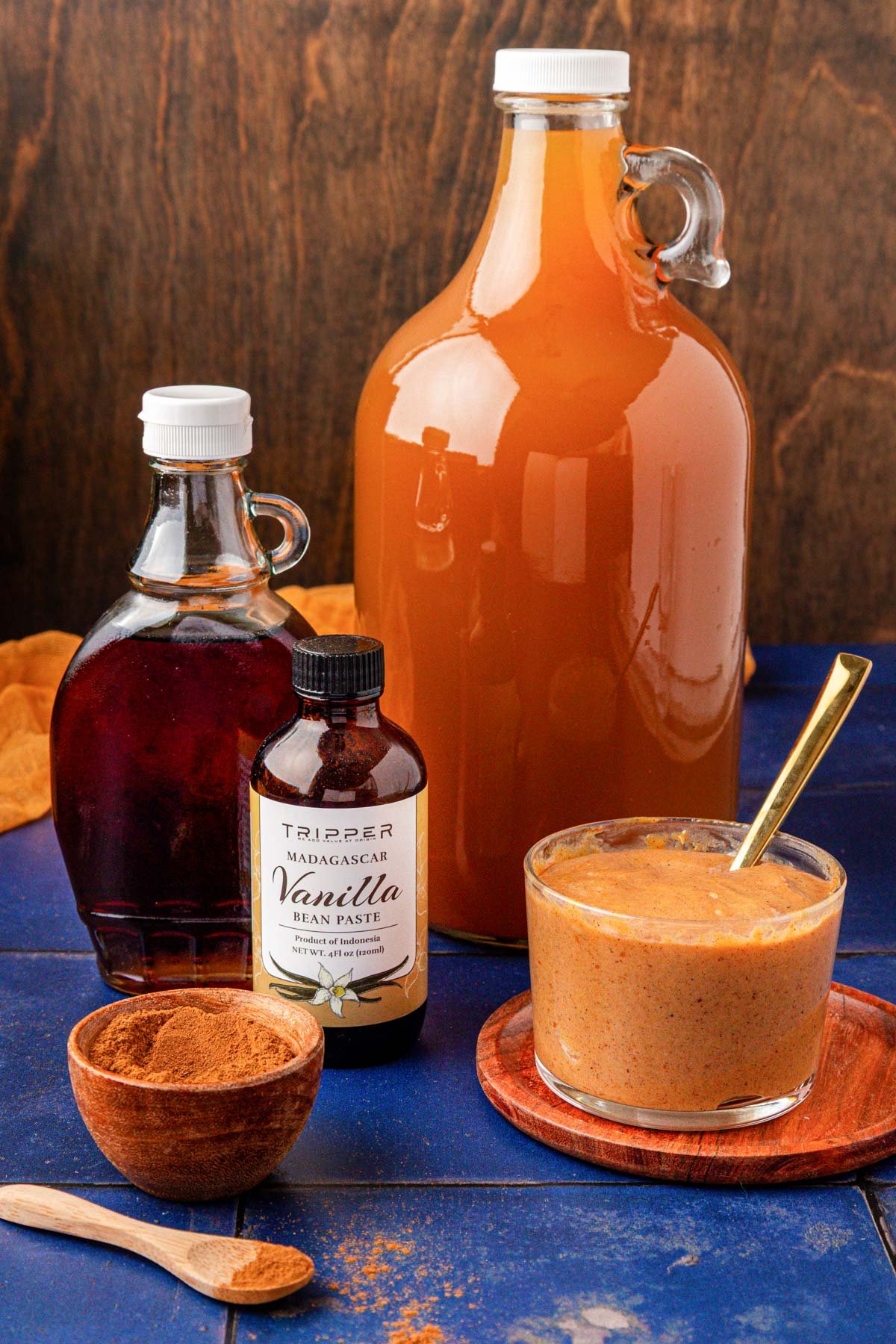 Ingredients to make Pumpkin Juice on a blue table.