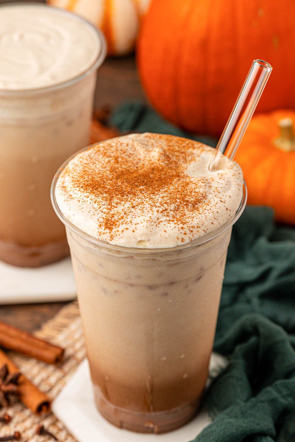 Pumpkin spice latte iced in a large cup on a table.