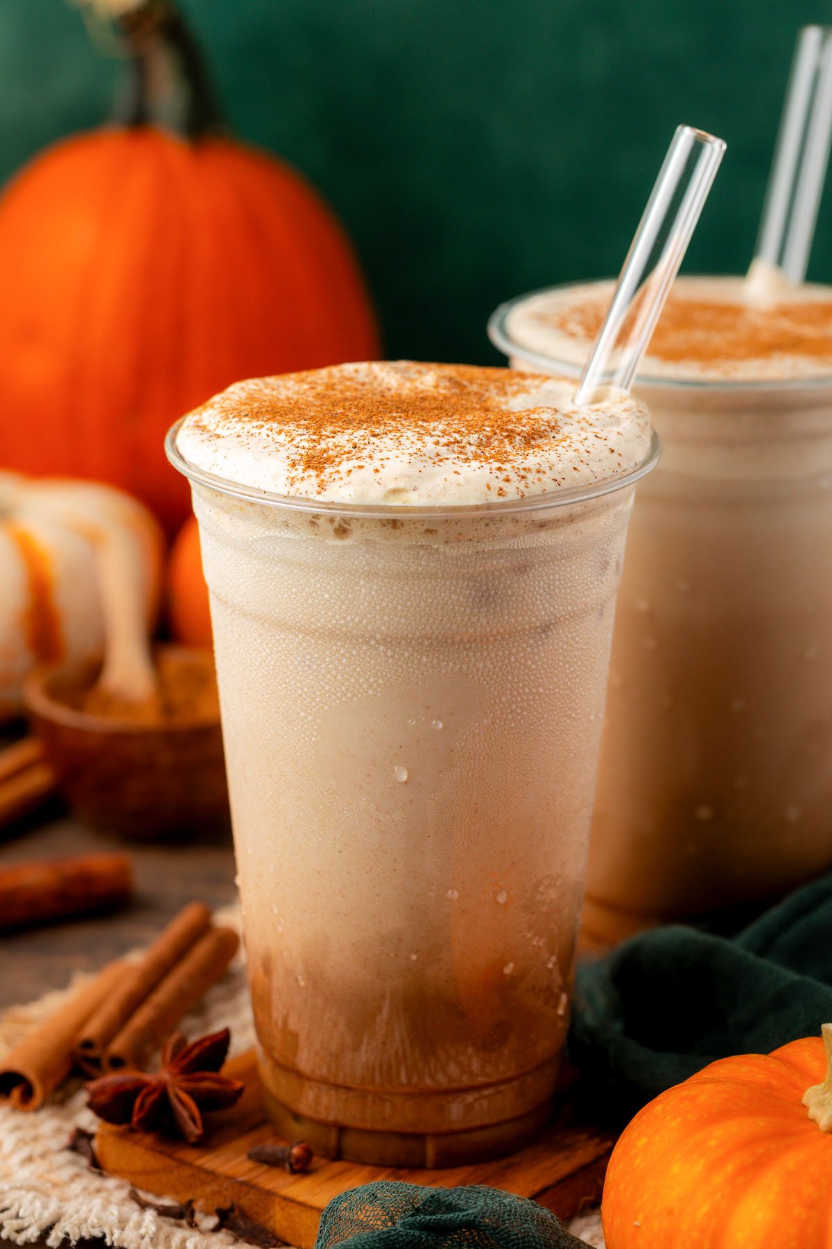 Two iced pumpkin lattes on a table.