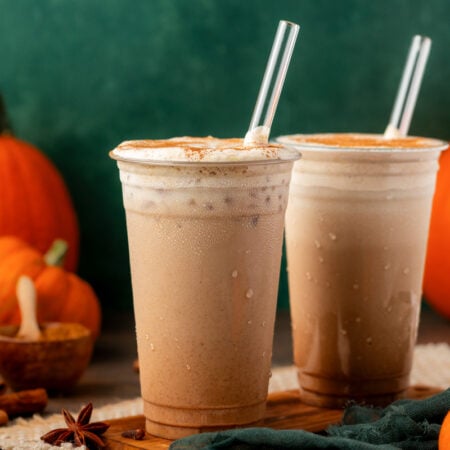 Two iced pumpkin lattes on a table.