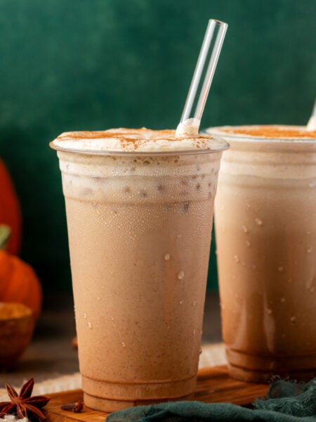 Two iced pumpkin lattes on a table.