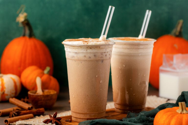 Two iced pumpkin lattes on a table.
