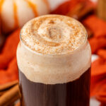 Close up of a glass of cold brew topped with pumpkin cold foam and pumpkin spice on top.