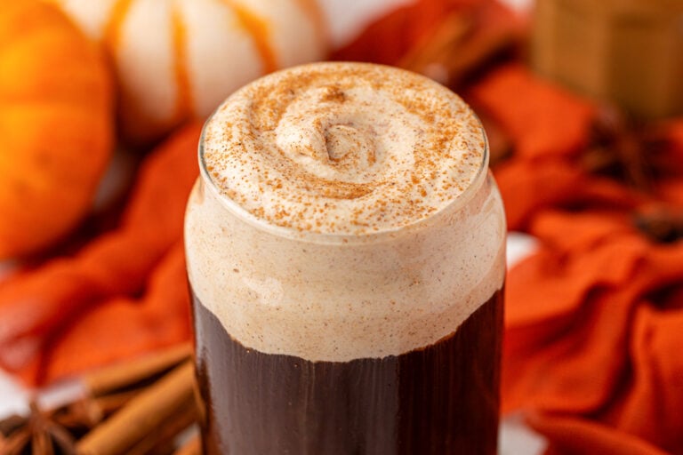 Close up of a glass of cold brew topped with pumpkin cold foam and pumpkin spice on top.