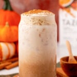 A glass filled with pumpkin cream chai latte on a table.