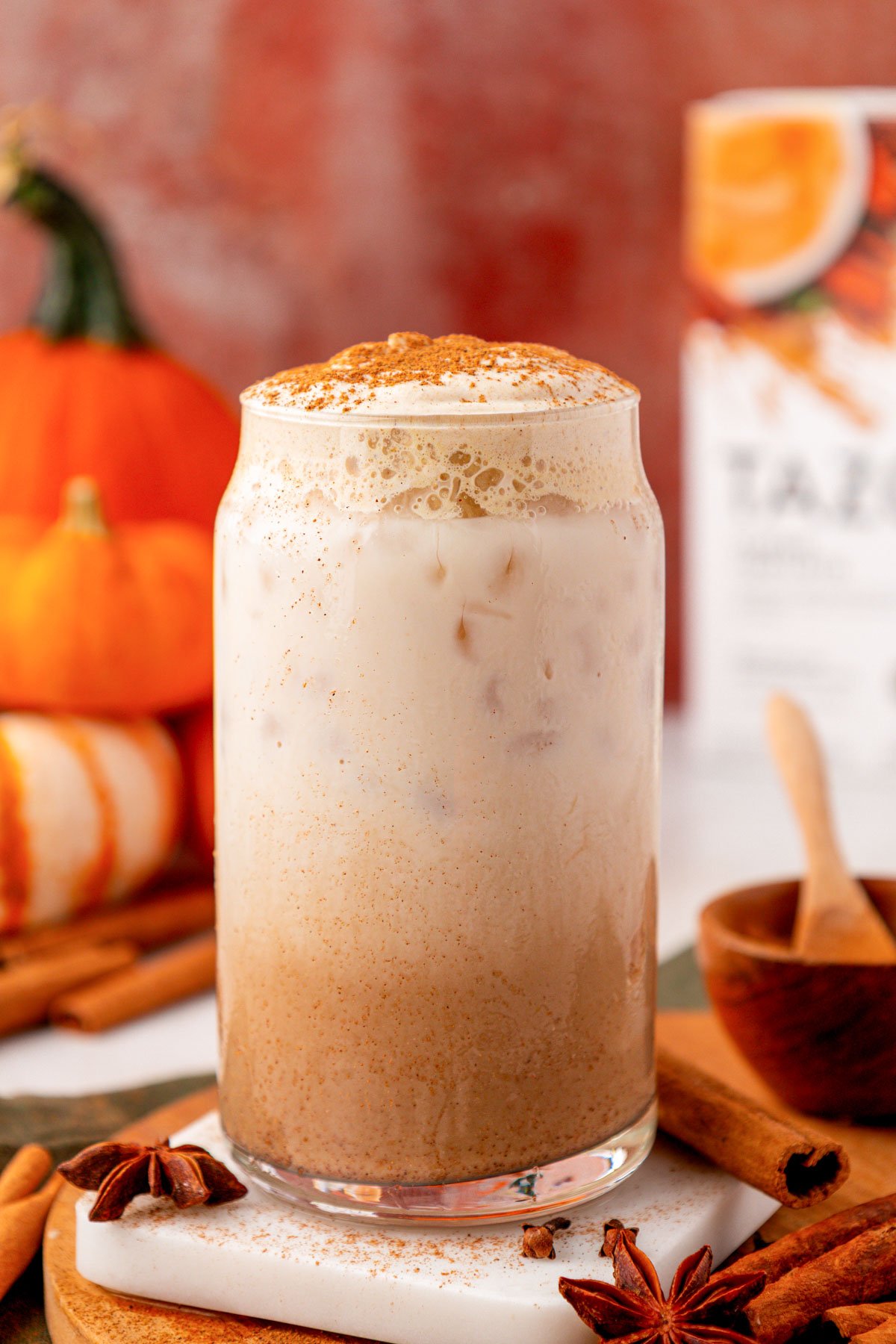 A glass filled with pumpkin cream chai latte on a table.