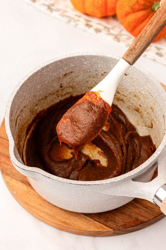 Pumpkin puree and spices are being cooked in a pot.