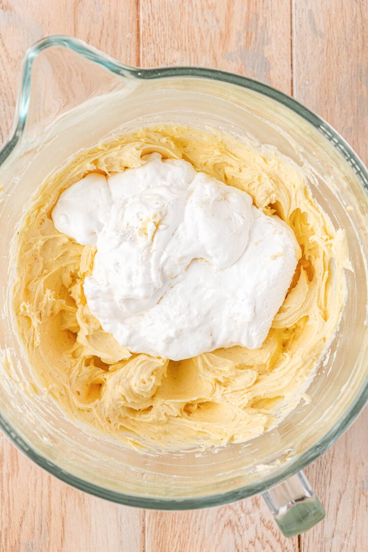 Marshmallow fluff being added to a mixing bowl to make frosting.