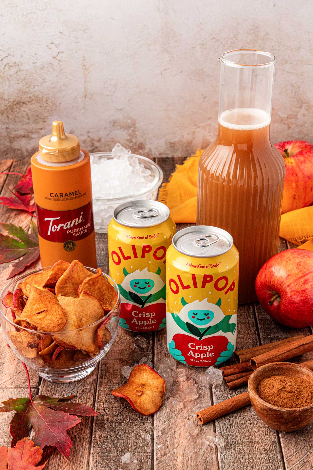 Ingredients to make an apple cider refresher drink on a wooden table.